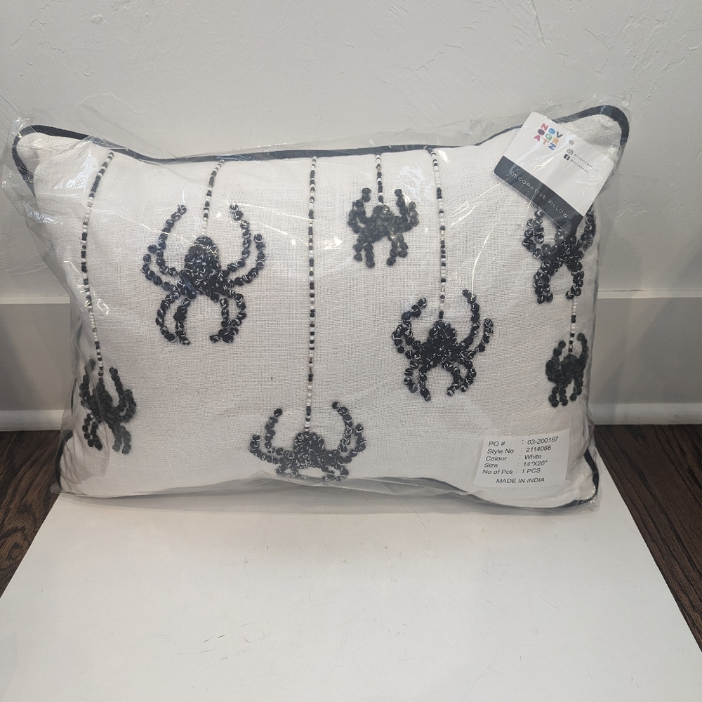 White pillow with black spiders.
